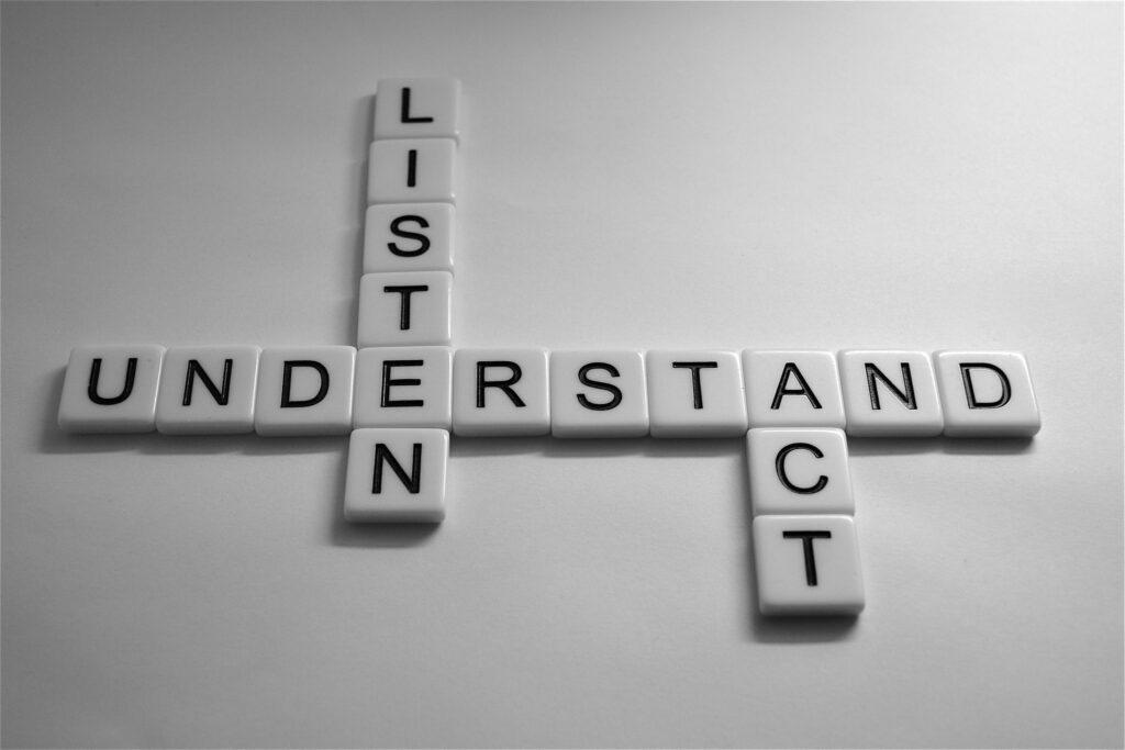 word tiles spelling out: listen, understand, act