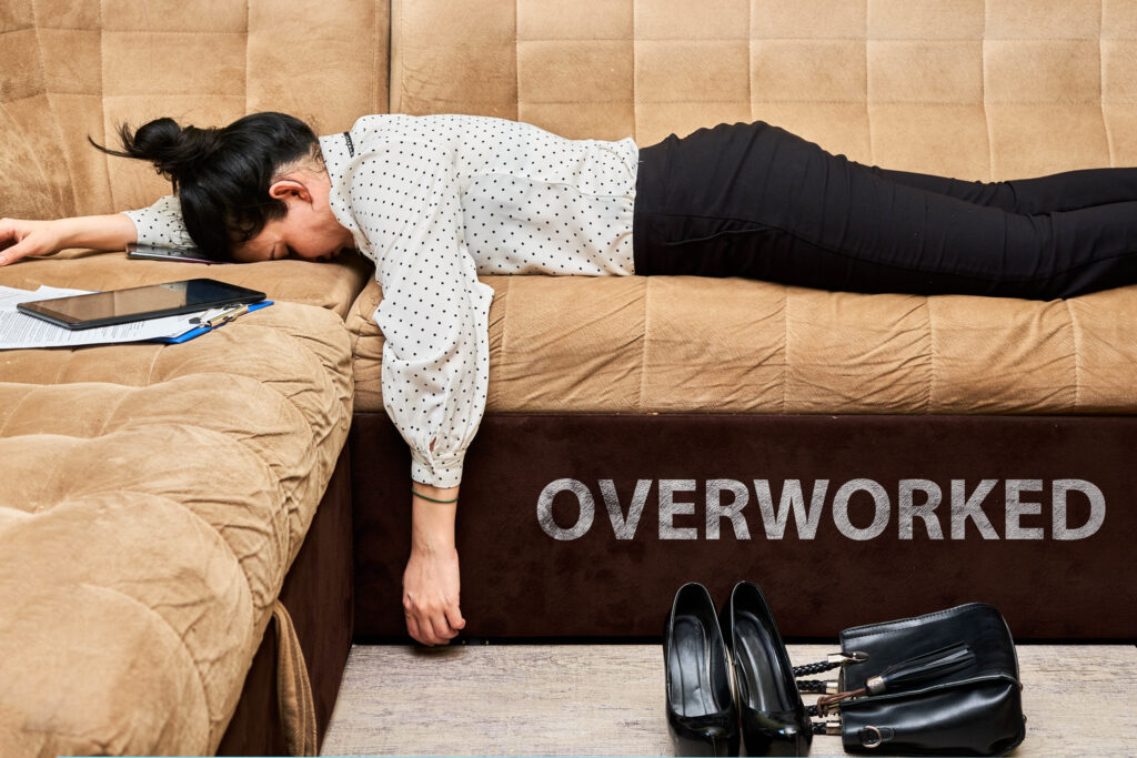 Exhausted lady laying on a couch with her work.